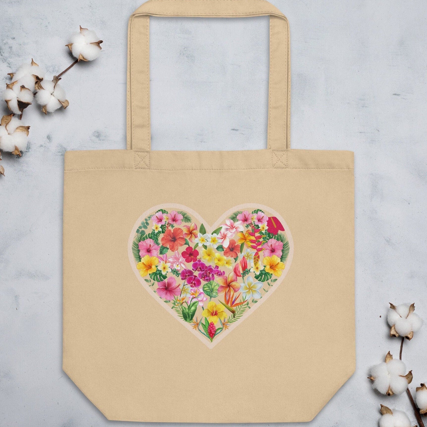 Beige tote bag with a floral heart design on a light gray background