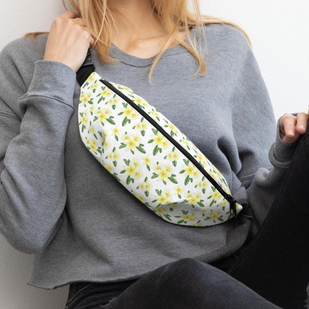 Person wearing a gray sweatshirt with a floral fanny pack.